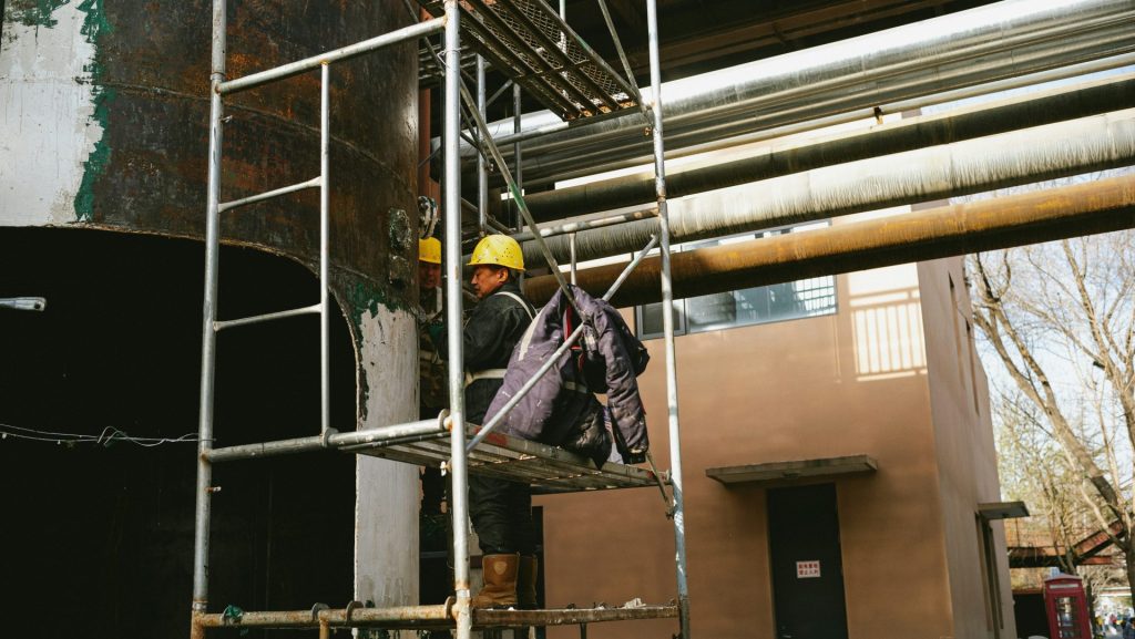 a man standing on a scaffold next to a building