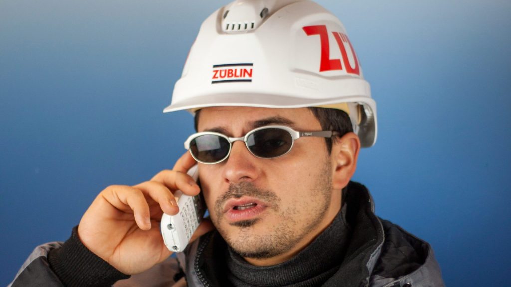 a man in a hard hat talking on a cell phone